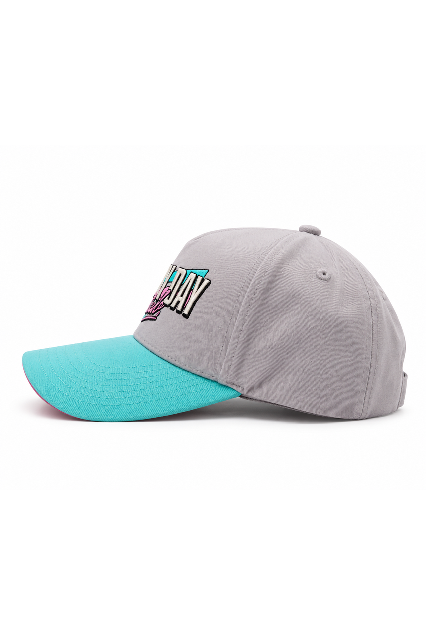 A baseball cap with a light gray crown and a bright turquoise visor, featuring a stylized embroidered logo on the front that reads 'DAY' in white, black, and turquoise.