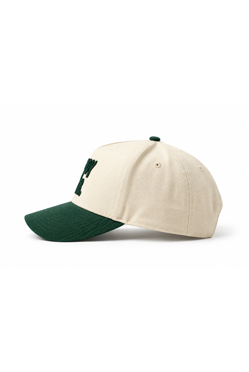 A baseball cap in off-white with a dark green curved brim and a dark green embroidered letter 'Y' on the front, shown against a plain white background.